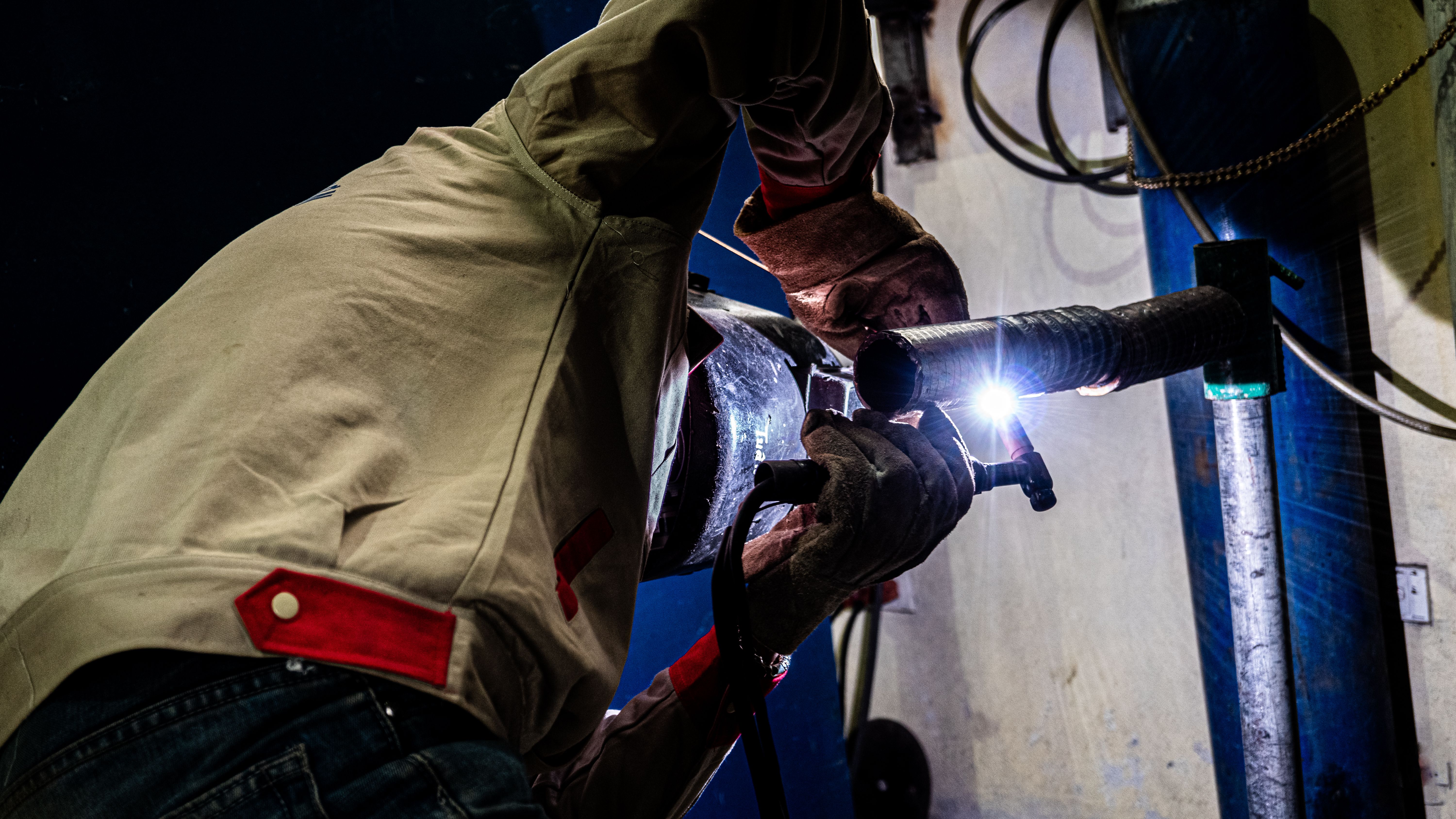 Welder working on industrial pipe